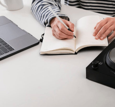Woman working script writing with books, focusing on crafting detailed and accurate scripts audio description services.