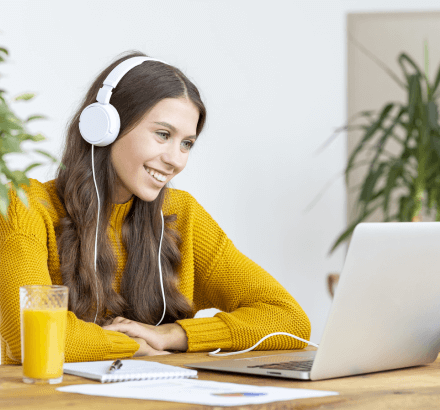 A woman working on laptop, engaged in an audio description ensuring precise narration with advanced features for accessible.