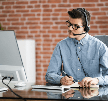 A man using a laptop for a virtual meeting, symbolizing personalized captioning services tailored to your requirements.