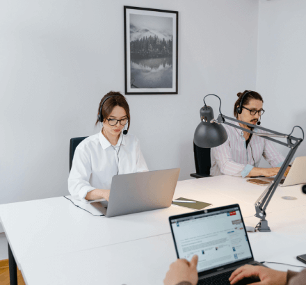 Man and woman with headsets discussing Spanish captioning and subtitling services, essential for accurate translations.