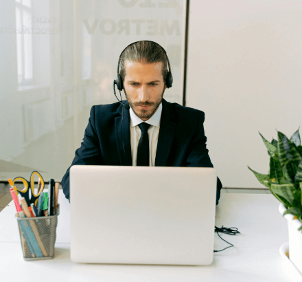 A man using a laptop, focused on delivering FCC and ADA-compliant captioning services for legal accessibility.