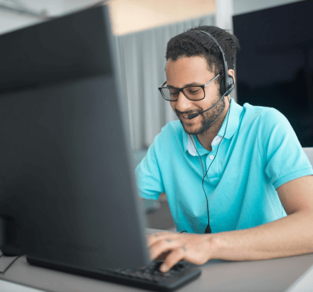 Man with headset working on a secure computer, highlighting confidential captioning services that protect sensitive content.