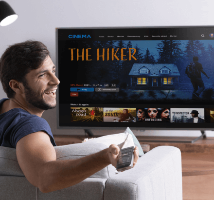 Man watching media content with captions by VC, depicting captioning services to engage viewers in media and entertainment.