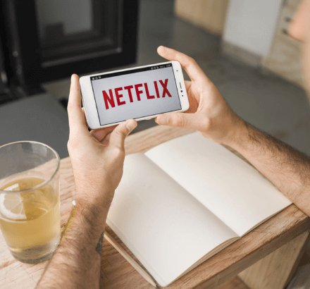 A smartphone displaying a video with closed captions, illustrating closed captioning services tailored for Netflix content.