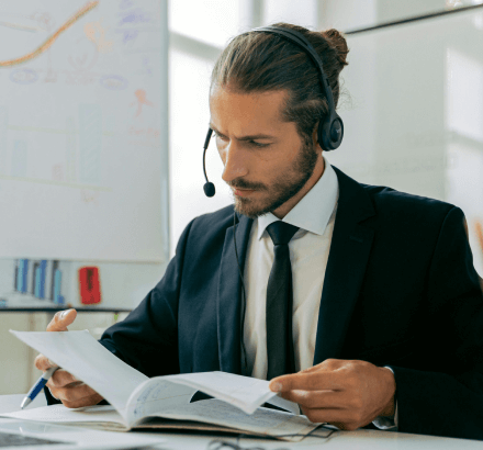 Man in a black suit jacket checking records, symbolizing professional French subtitling ensuring accuracy and quality.