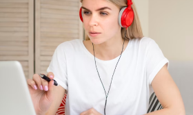 Headphone-wearing person transcribes and translates German audio to English, showcasing professional captioning services.